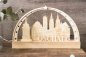 Preview: LED-Schwibbogen komplett aus Holz mit gravierter Stadtsilhouette von Oschatz (Brunnen, Rathaus, Kirchtürme) und dem Schriftzug „Oschatz", umrahmt von Sternen, warmweißes Licht
